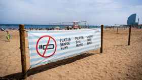 Cartel de prohibición de playas sin humo en la Barceloneta / LUIS MIGUEL AÑÓN (MA)