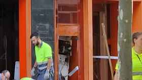 Operarios recogen los trozos del cajero tras la explosión en Santa Coloma / CEDIDA