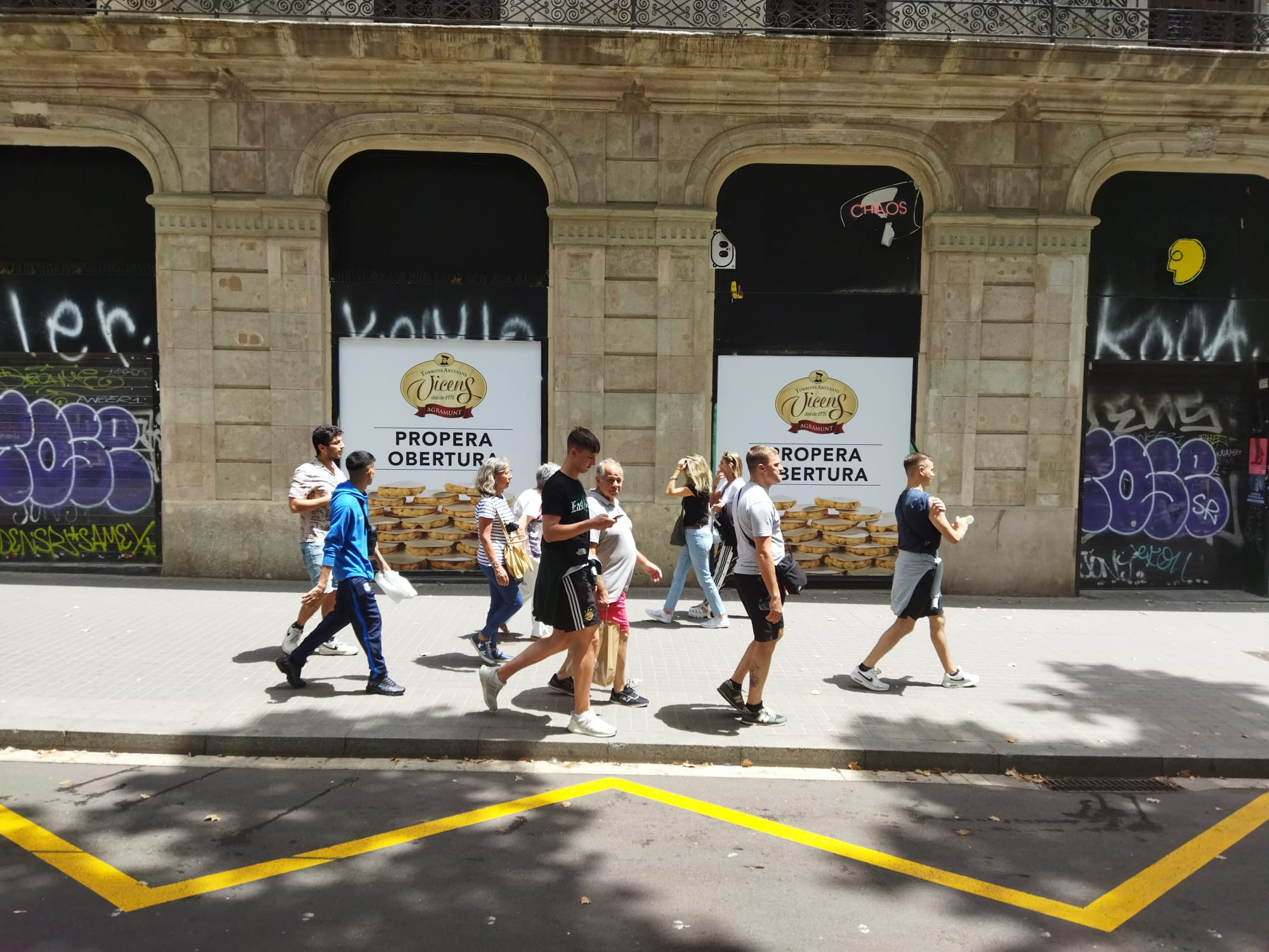 Un grupo de turistas pasa delante de Torrons Vicens en la Rambla antes de abrir / METRÓPOLI - JORDI SUBIRANA