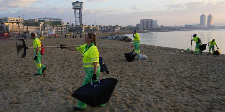Operarios limpiando las playas de Barcelona / EFE
