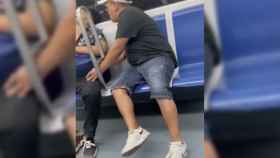 Captura de pantalla del momento del vídeo en el que el carterista roba a un hombre dormido en el metro de Barcelona / TWITTER