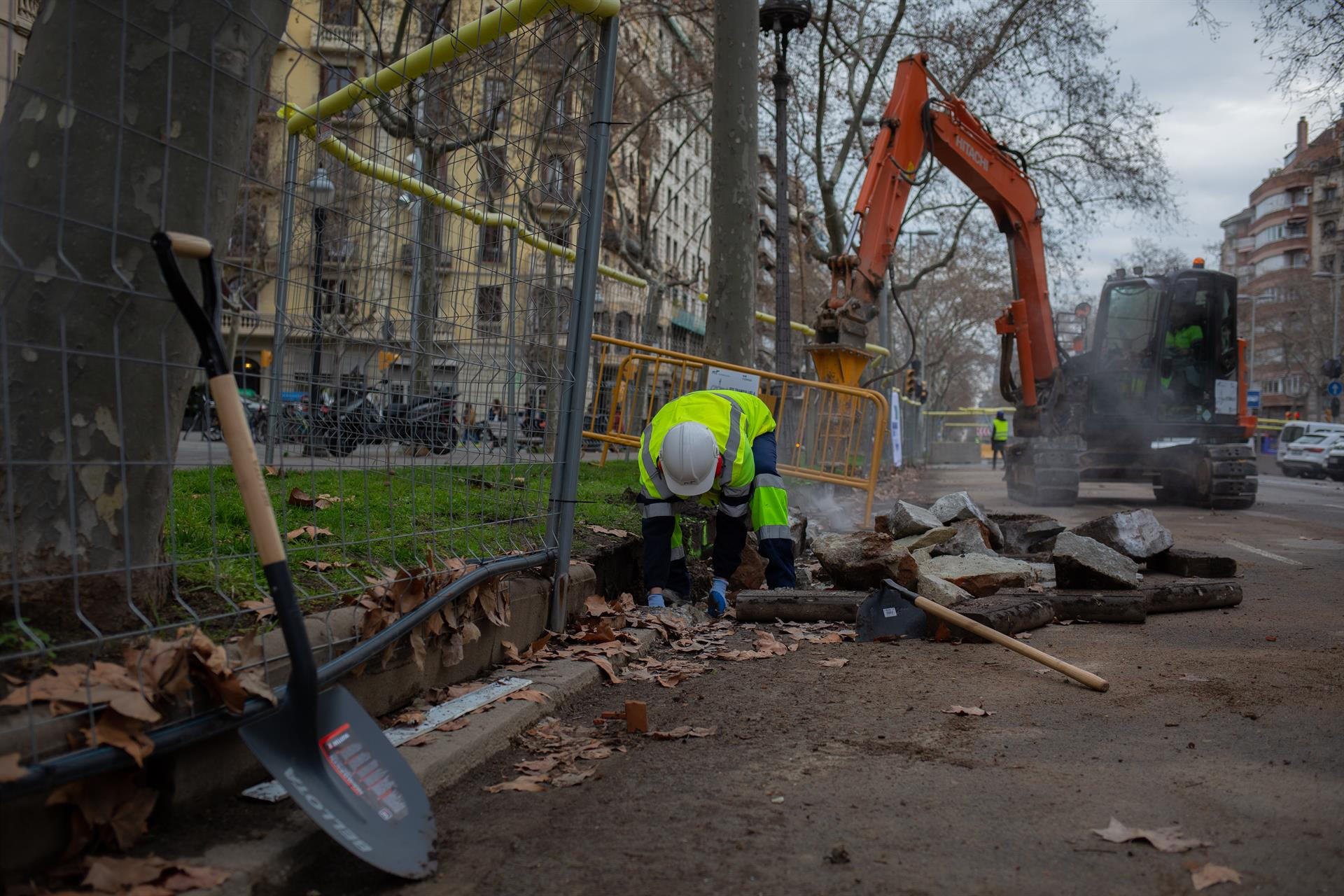 Un obrero y una máquina excavadora trabajan en las obras para unir el tranvía por la Diagonal de Barcelona / EUROPA PRESS