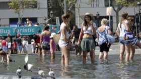 Dos mujeres se refrescan en un fin de semana de temperaturas máximas en Barcelona / EFE