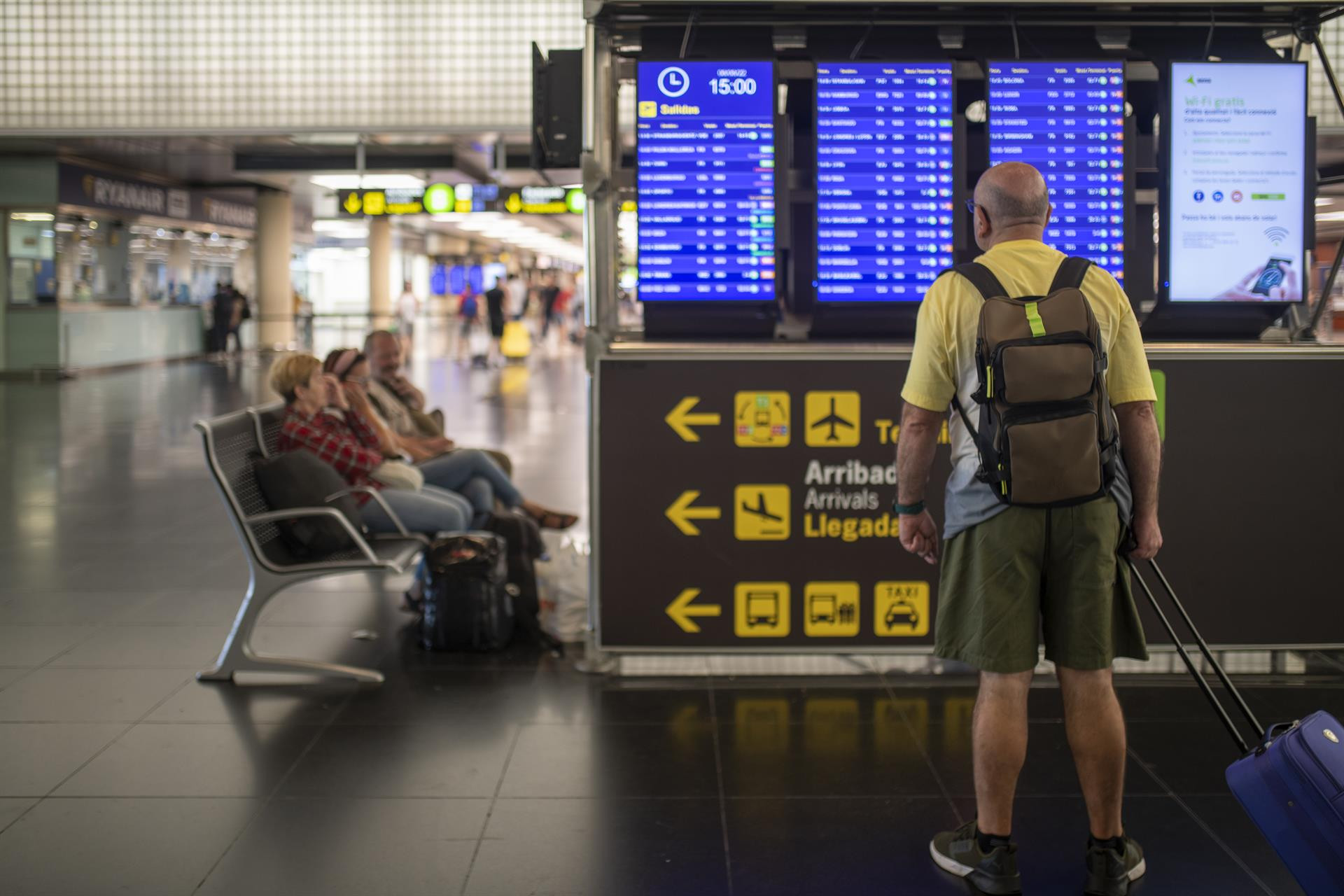 Un hombre mira un panel de llegadas y salidas en el Aeropuerto Josep Tarradellas Barcelona-El Prat / EUROPA PRESS
