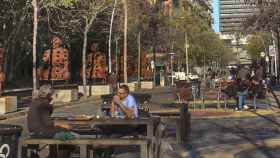 Superilla de Barcelona con varias personas sentadas en las mesas