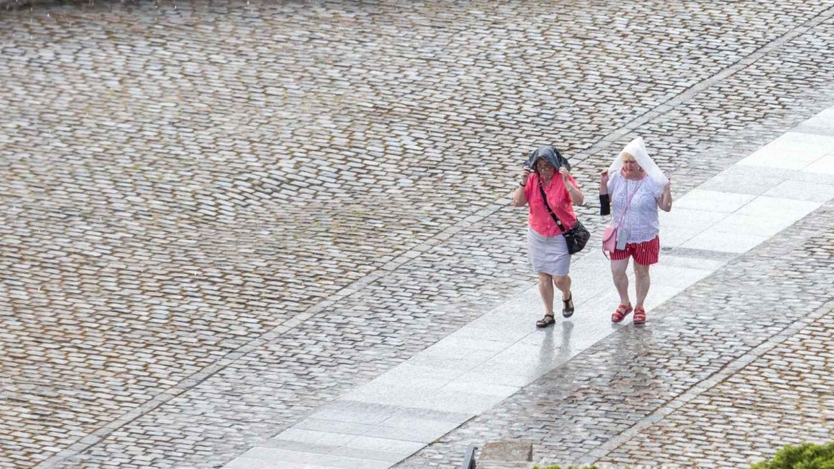 Dos mujeres se protegen de la lluvia / EFE