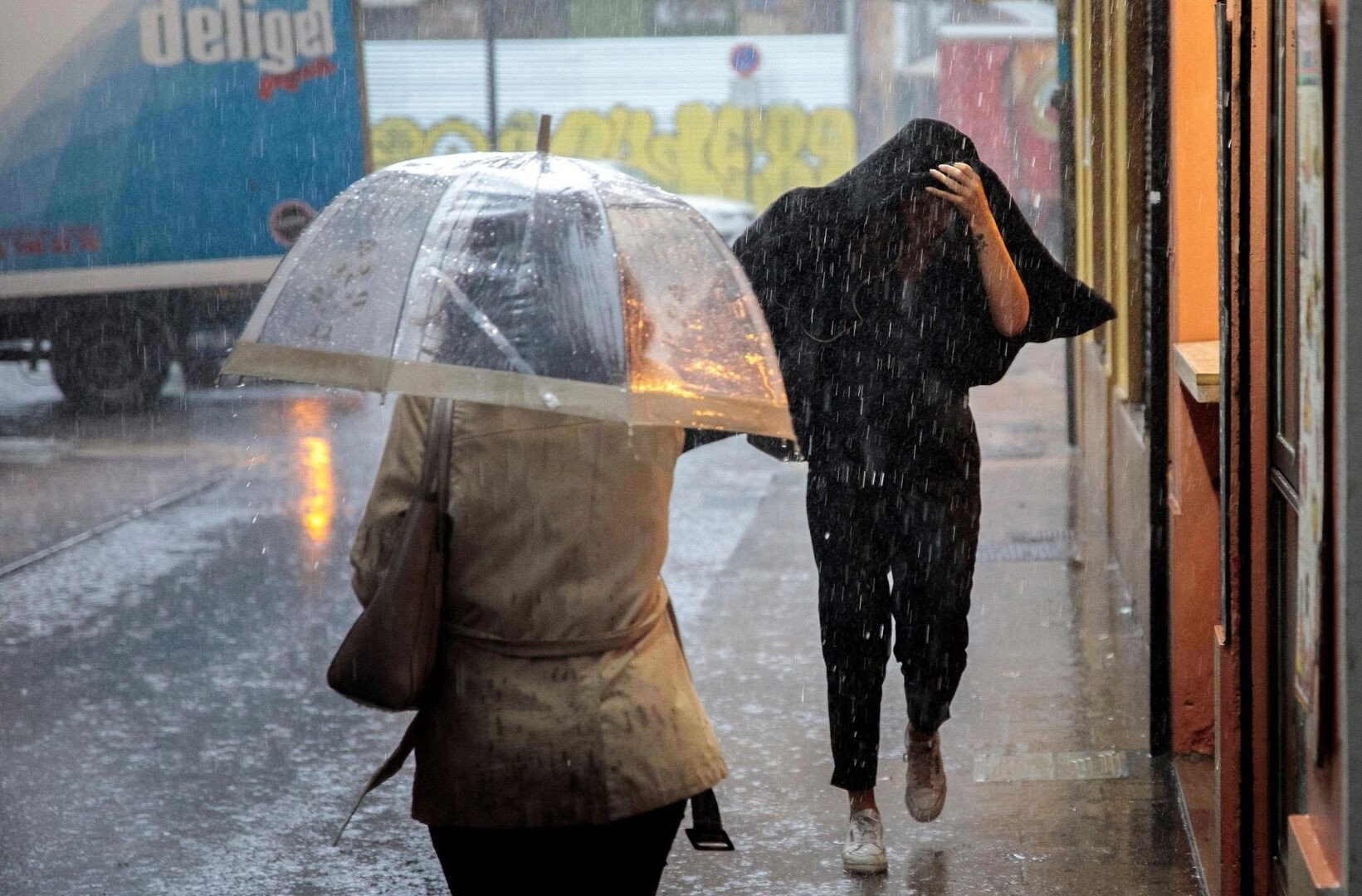 Dos personas se resguardan de un temporal de lluvia / EFEl