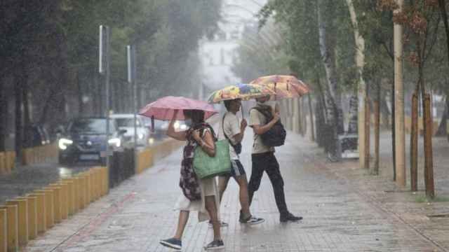 Tres personas se cubren de la lluvia con paraguas / EUROPA PRESS