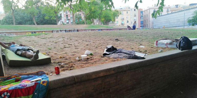 Un hombre duerme sobre el colchón en el parque de Sant Pau del Camp rodeado de basura / CEDIDA