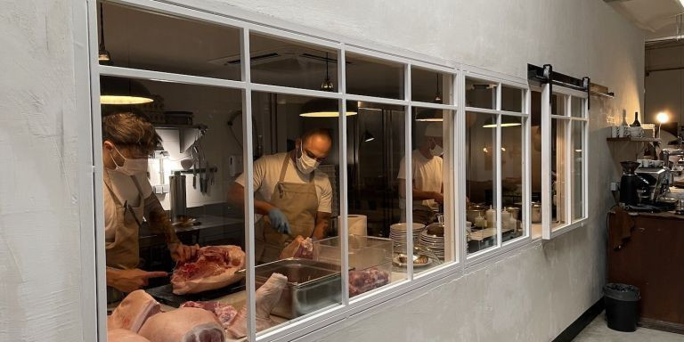 Cocineros a través de un ventanal del restaurante del Eixample de Sartoria Panatieri / BMAGAZINE