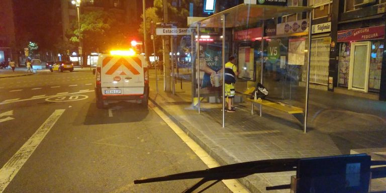 Un operario de TMB limpia una marquesina de bus de carteles de la huelga / CGT