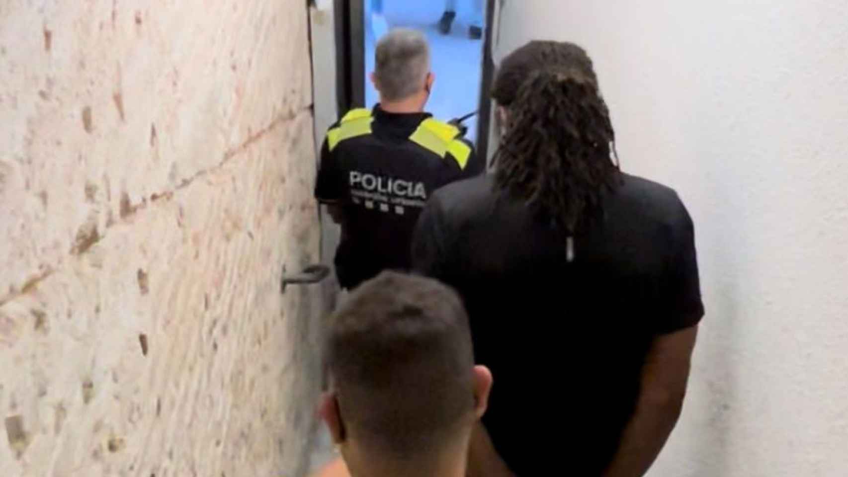 Agentes de Mossos y Guardia Urbana con un detenido a la salida del piso de Ciutat Vella / GUB