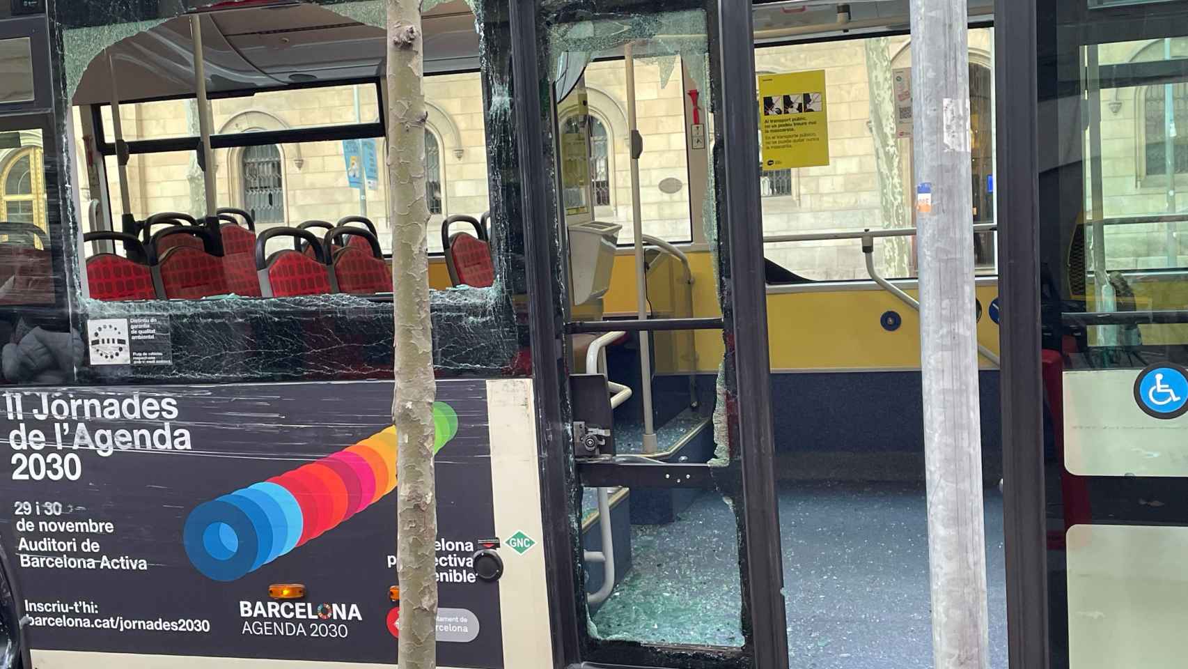 Imagen del autobús que ha sufrido el accidente con una ventana y puerta rotas en Barcelona / METRÓPOLI