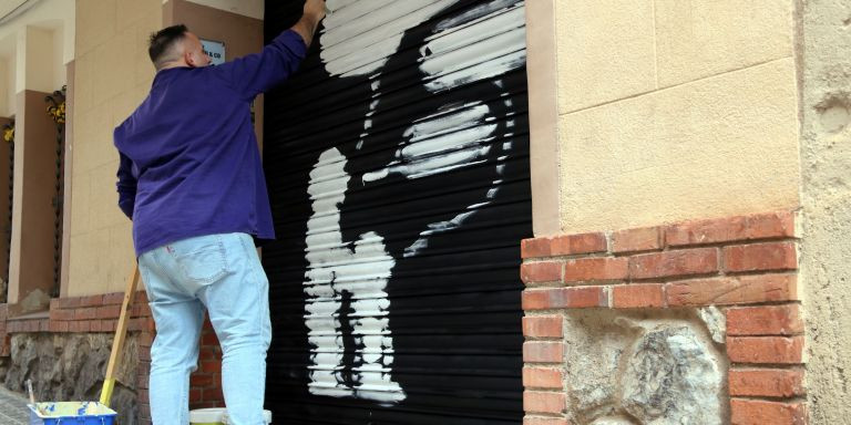El artista Javirroyo haciendo un grafiti en una persiana / ACN