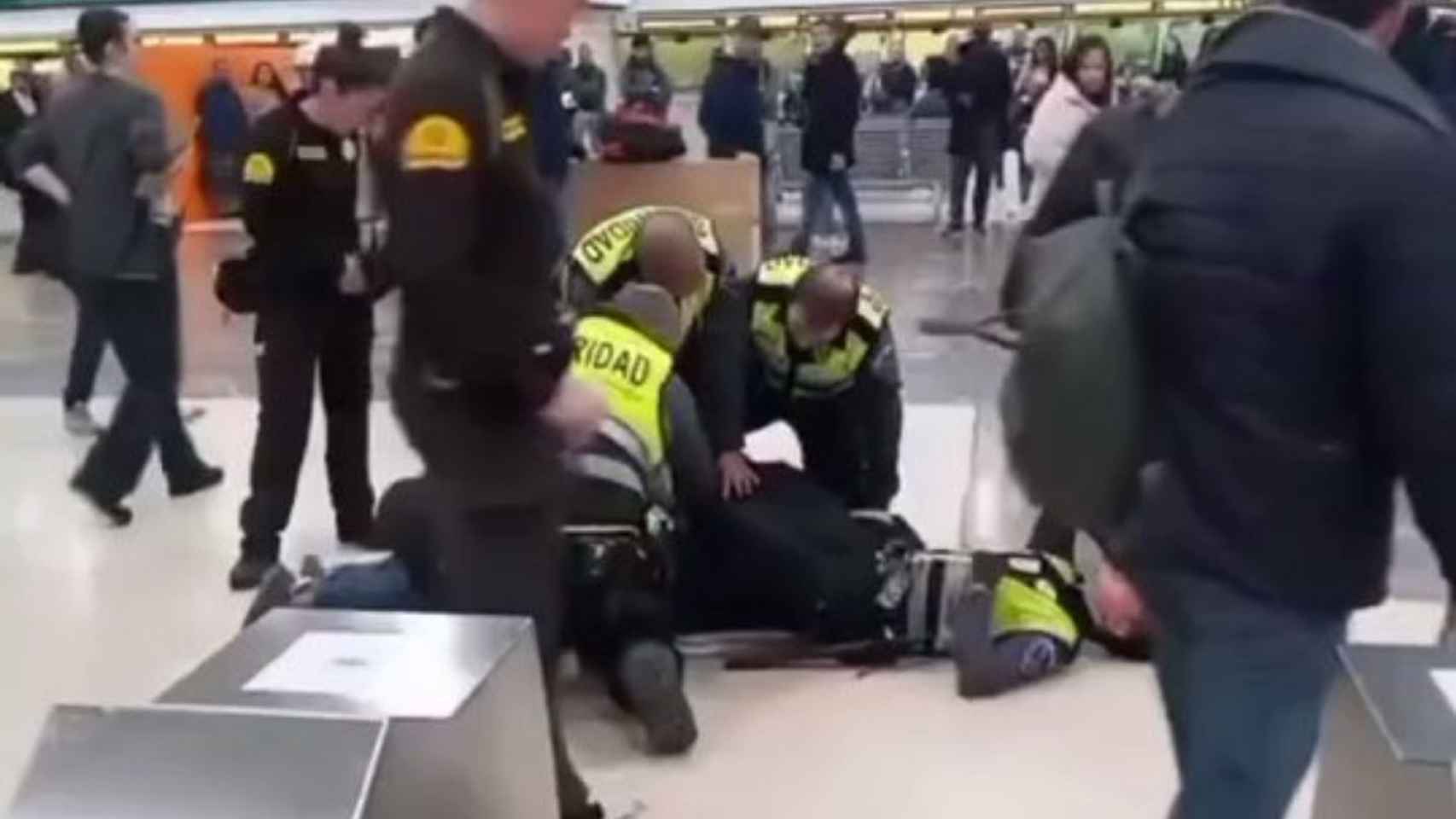 Fotograma del vídeo que muestra al vigilante herido y a otros miembros de seguridad reduciendo al agresor / TWITTER ADN