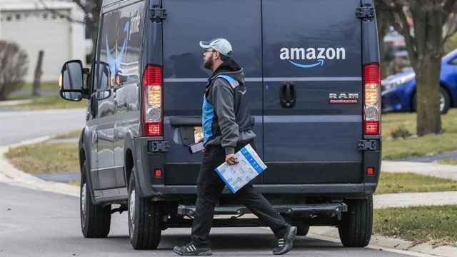 Un repartidor de Amazon con una furgoneta / EFE