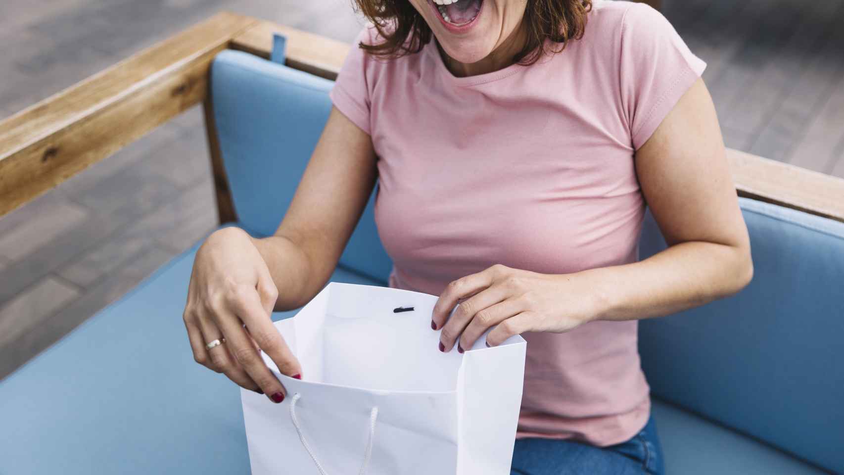 Mujer abriendo una bolsa de papel / FREEPIK