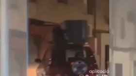 Un hombre subido a un maletero en Terrassa y aguantando una gran carga /SOCIAL DRIVE