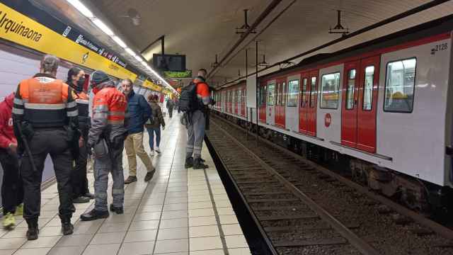 Vigilantes del metro rodeando a una persona que había perdido un anillo y buscando el objeto / A.G - M.A