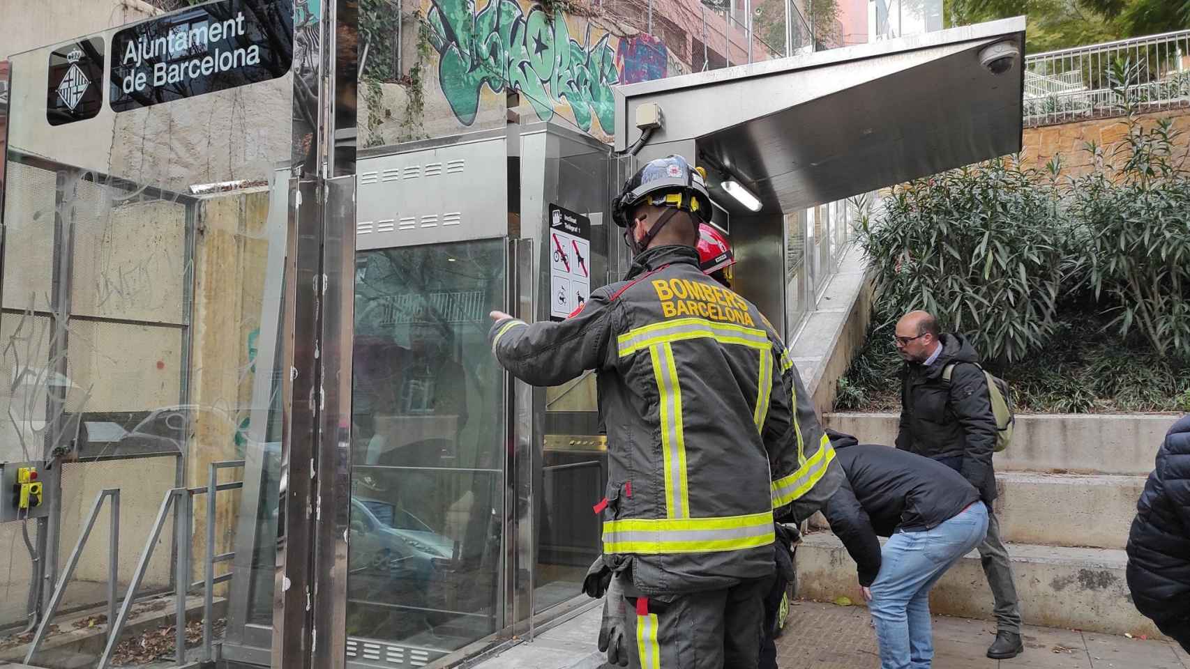 Los bomberos sacando a la niña y a su abuelo del ascensor de la calle Telègraf / TWITTER ESCOLA DEL MAR