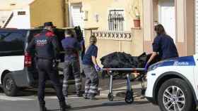 Personal de los servicios funerarios transportan el cadáver en Cornellà, presuntamente asesinado por su hermano / EFE-Alejandro García