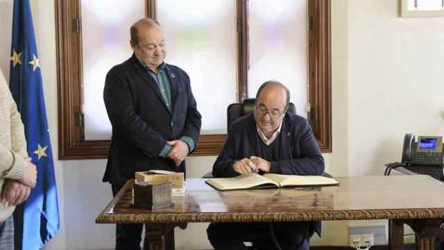 El ministro de Cultura y Deporte, Miquel Iceta, firma el Libro de Honor del Ayuntamiento de Viladecans junto al alcalde, Carles Ruiz  / DIESTRO-ÁLVAREZ - AYUNTAMIENTO DE VILADECANS