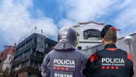 Fotomontaje de dos agentes de los Mossos d'Esquadra delante de los edificios okupados de la Bonanova