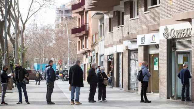 Una cola de personas esperando en una oficina de correos