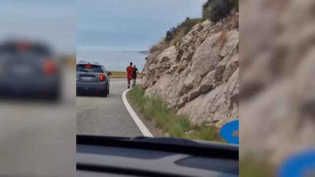 Dos jóvenes en patinete y sin protección circulan por la carretera de la costa del Garraf / REDES