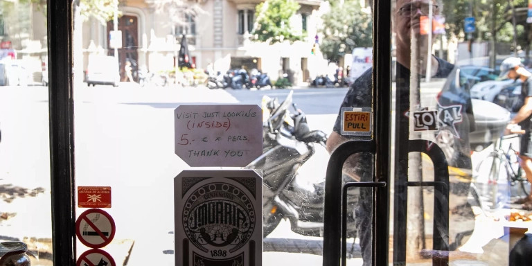 El pequeño cartel en el que se piden cinco euros para entrar, en el Colmado Múrria / GALA ESPÍN