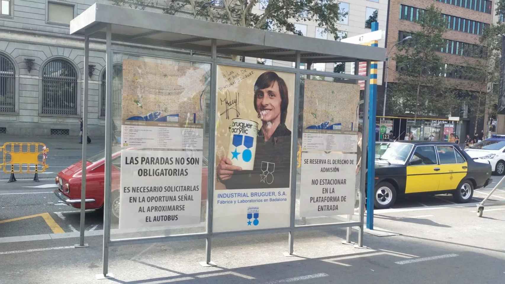 Marquesina en la plaza de Catalunya decorada con un anuncio de Johan Cruyff y pinturas Bruguer / BETEVÉ