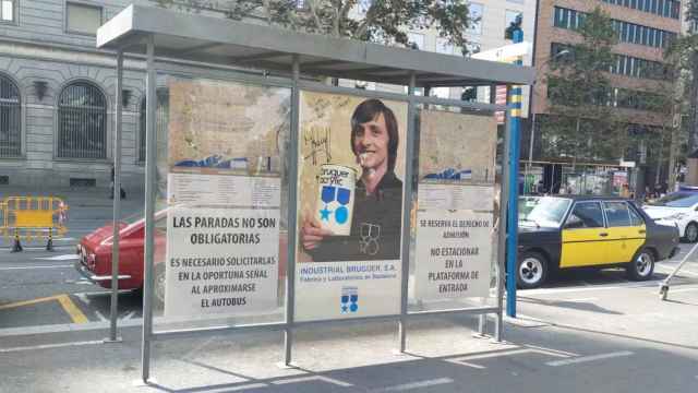 Marquesina en la plaza de Catalunya decorada con un anuncio de Johan Cruyff y pinturas Bruguer / BETEVÉ