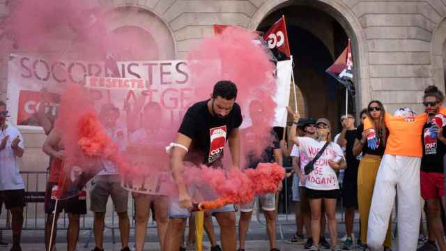 Una persona con una bomba de humo durante una concentración de CGT-Socorristas, en la plaza Sant Jaume / David Zorrakino - Europa Press