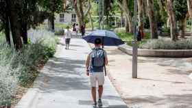 Un hombre se pasea con paraguas para evitar el sol / Ricardo Rubio - Europa Press