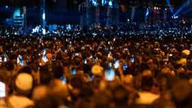 Una multitud graba el Piromusical de la Mercè de 2023 desde la avenida de Maria Cristina / LUIS MIGUEL AÑÓN - METRÓPOLI