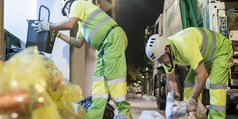 Dos empleados de la basura recogiendo unas bolsas durante la temporada de verano / AJUNTAMENT DE BARCELONA