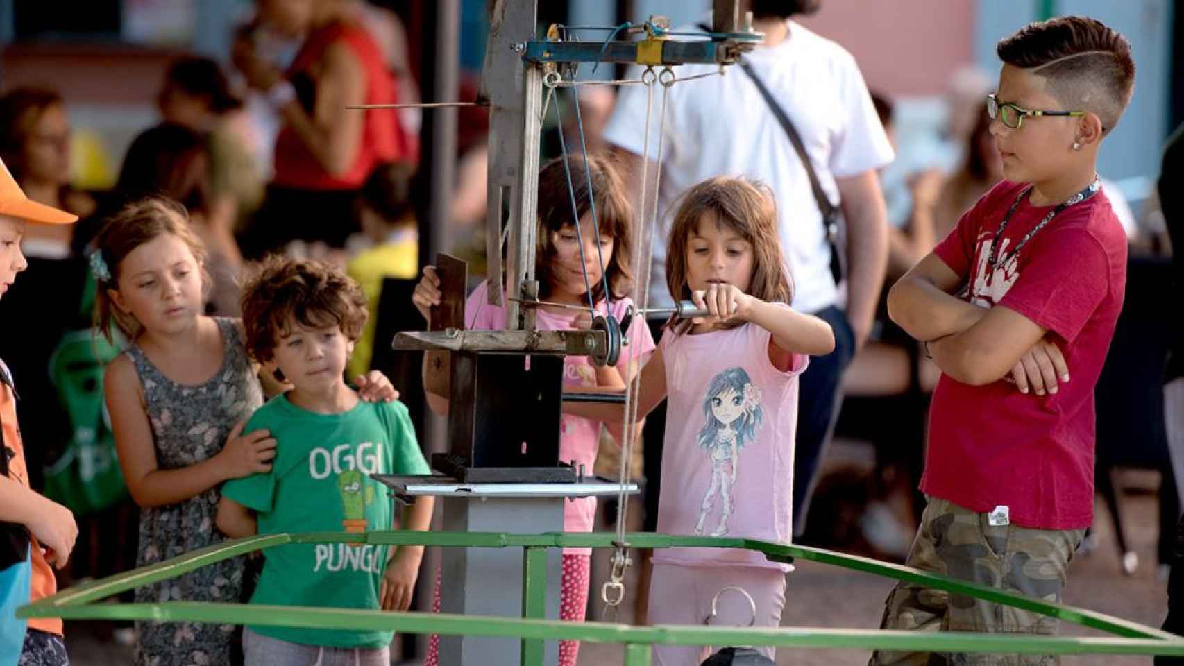 Niños jugando con los juegos reciclados de Guixot de 8 en una feria o mercado
