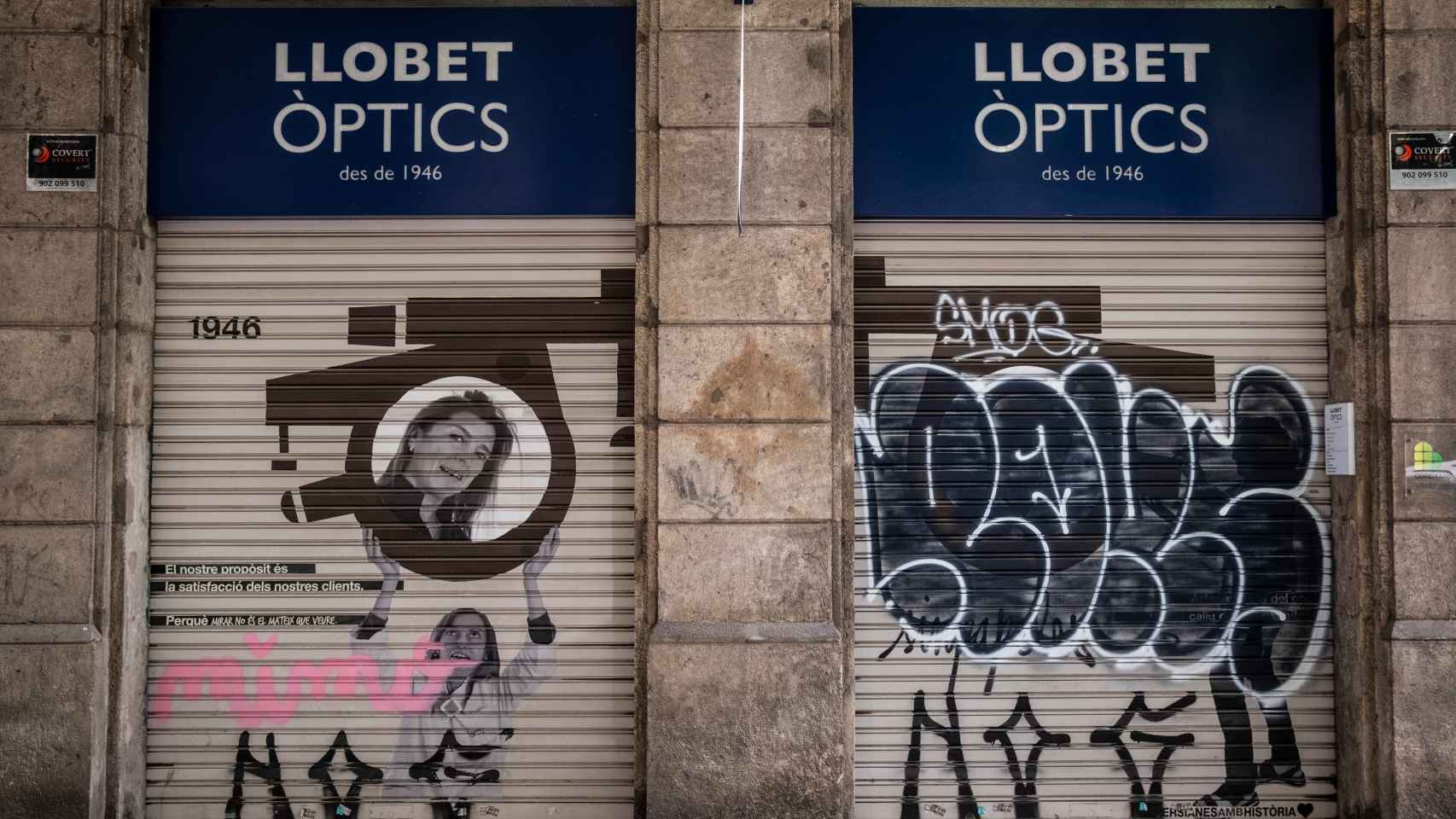 Persiana grafiteada de la tienda Llobet Òptics, en la Dreta del Eixample de Barcelona