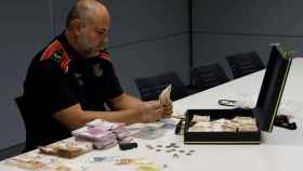 Imagen de un agente de Mosso d'Esquadra que mira los billetes de 50 falsos