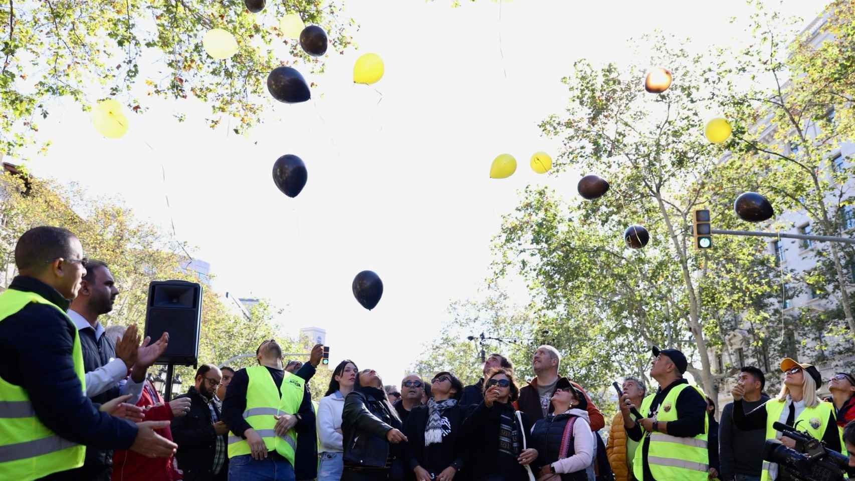 Taxistas y familiares de Carlos lanzando globos negros y amarillos al aire