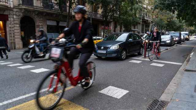 Coches, motos y bicicletas circulando por la calle València, en el Eixample barcelonés