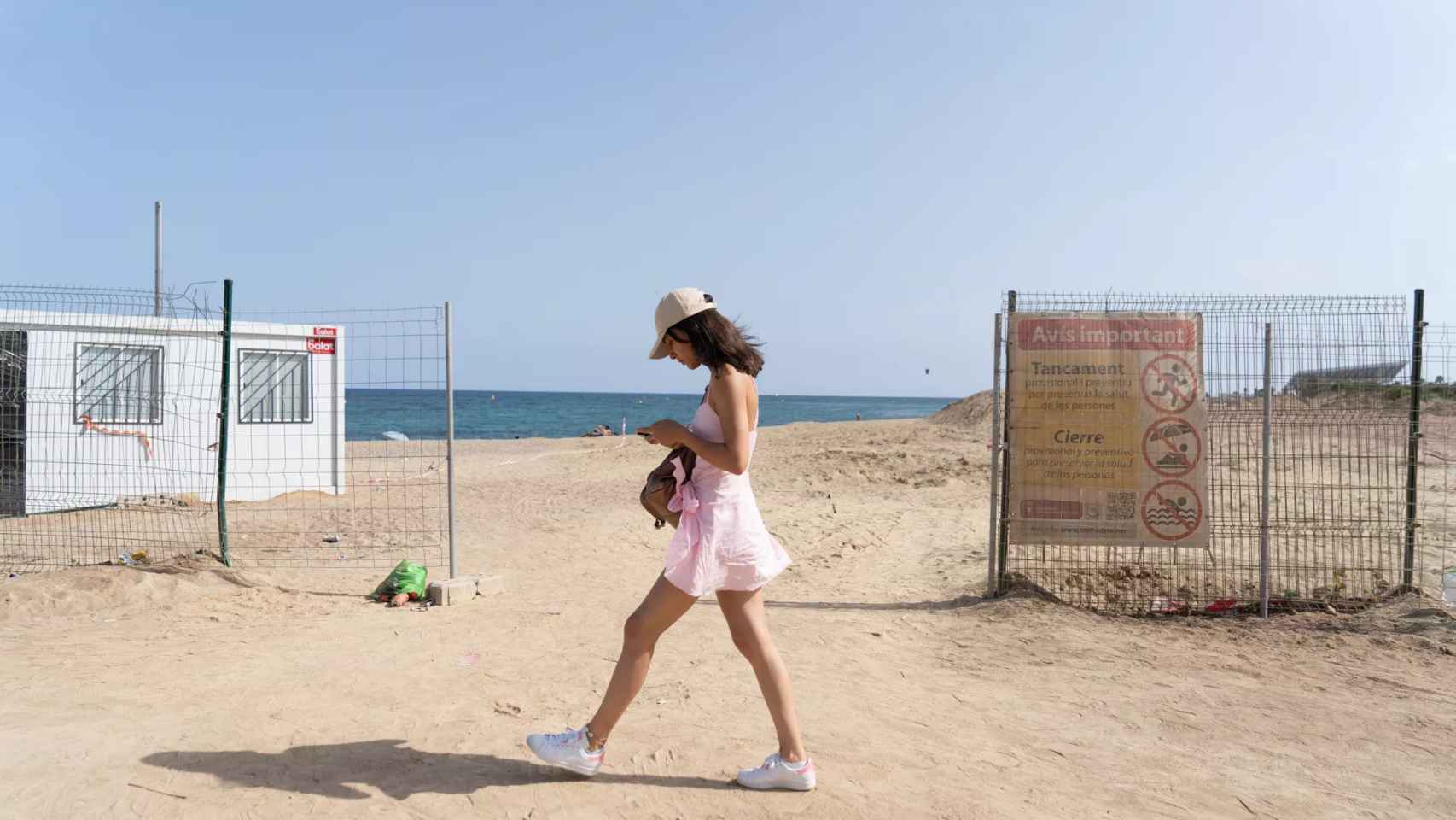 Una chica paseando por la playa contaminada de Sant Adrià